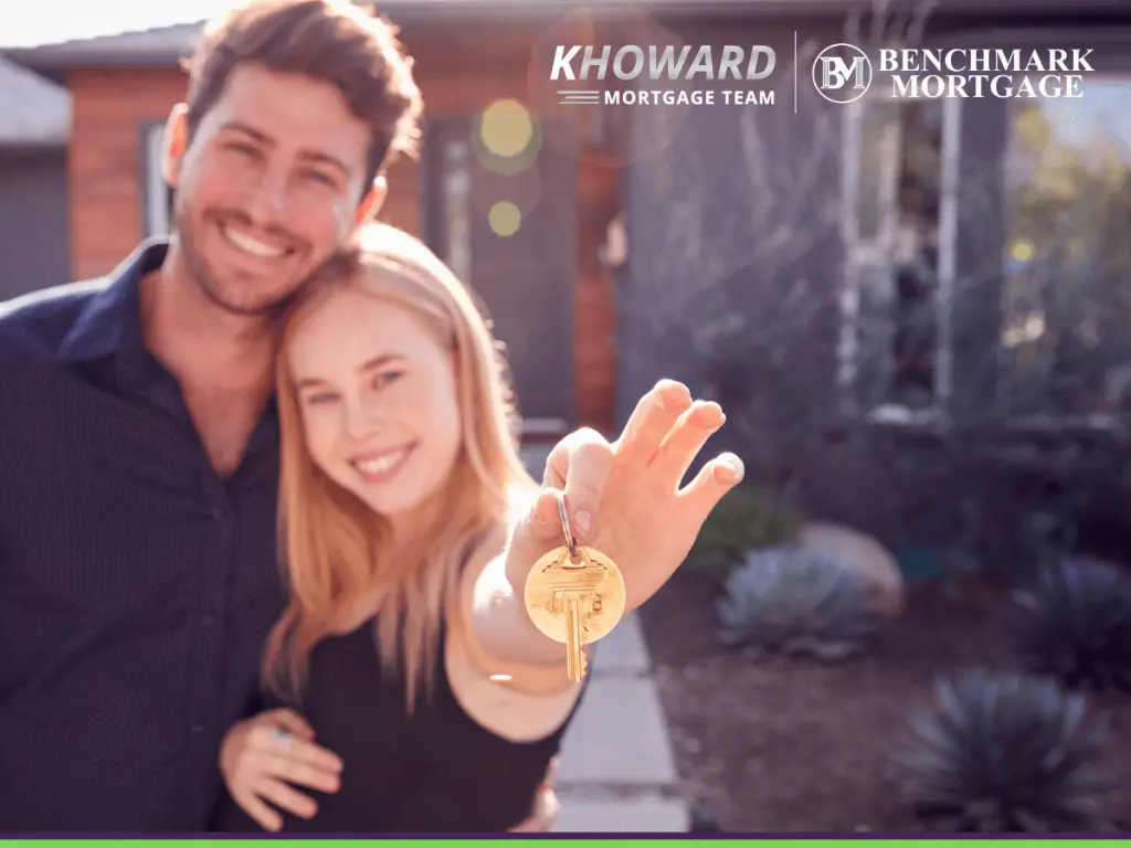 Happy married couple standing outdoors in front of new home holding keys
